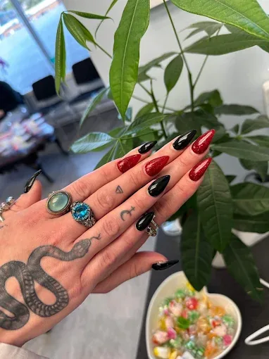 Alternating red glitter and black almond nails